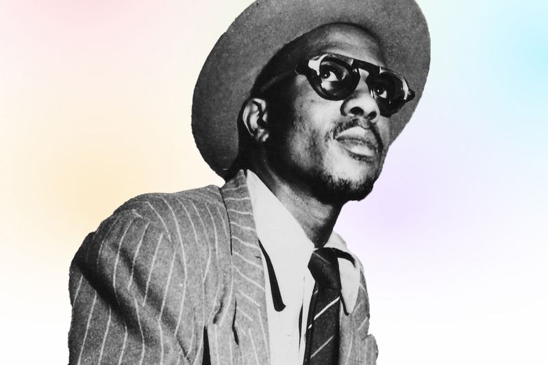 Headshot of Thelonious Monk in a suit, looking over top of the camera